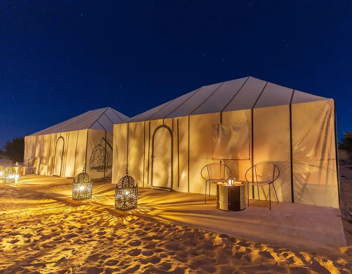 Travellers watching the sunset over the Sahara dunes