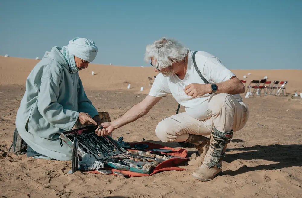 A Moroccan guide showing a traveller how tea is prepared in the desert